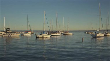 Monterey Körfezi, Kaliforniya 'da günbatımında yelkenli tekneli sakin marina sahnesi