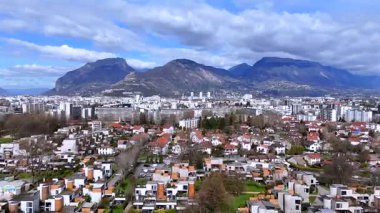 Grenoble banliyösünün alçak drone görüntüsü Alpler ve bulutlu kırmızı çatı evleri