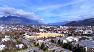 Grenoble Fransa üzerindeki İHA panoraması parlak mavi gökyüzünün altındaki evleri ve dağları gösteriyor