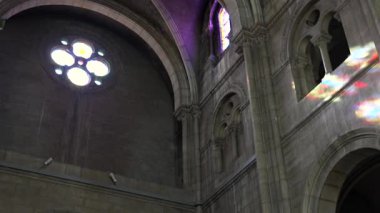 Kemerli mimari ve renkli yansımalarla sakin bir kilise.