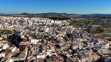 Puente Genil Endülüs İspanya 'nın panoramik manzarası. Beyazlatılmış evler, kırmızı fayanslı çatılar ve açık mavi gökyüzü altındaki tepeler.