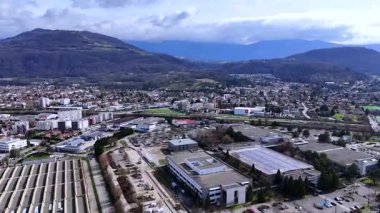 Grenoble endüstriyel çatılarının insansız hava aracı antenleri. Güneş panelleri, ağaçlar, otoparklar ve spor alanları.