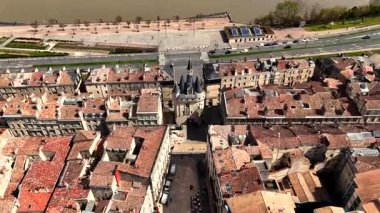 Bordeaux tarihi merkezinin video klibi Porte Cailhau kapısı, nehir kenarında gezinti güvertesi, taş köprü ve çamurlu Garonne nehri üzerinde geçen bir tur teknesi.