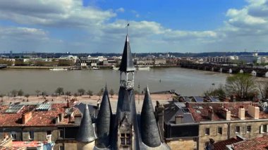 Ortaçağ Porte Cailhau kapısının kırmızı kiremitli çatıları ve çamurlu Garonne nehri boyunca uzanan Pont de Pierre köprüsü olan insansız hava aracı videosu.