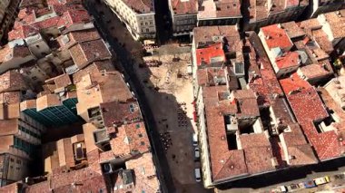 Güneşli bir günde tarihi Bordeaux dar sokağının tepeden aşağıya, kafe terası ve kiremitli çatıları olan insansız hava aracı görüntüleri.