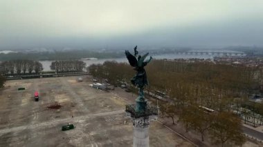 Girondins 'in etrafındaki sinematik hava yörüngesinde yumuşak sabah sisinde bronz melek heykeli