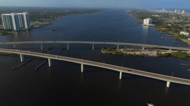 Daytona Sahili yakınlarındaki geniş nehir koridorunun hava aracı görüntüsü güneşli bir günde iki köprünün sakin su yüzeyi ve kentsel kıyı şeridini gösteriyor.