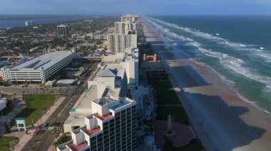 Daytona Sahili Florida 'nın geniş hava aracı görüntüsü açık güneşli bir günde kıyı boyunca uzanan kumlu kıyı şeridi ve Atlantik Okyanusu dalgalarını gösteriyor.