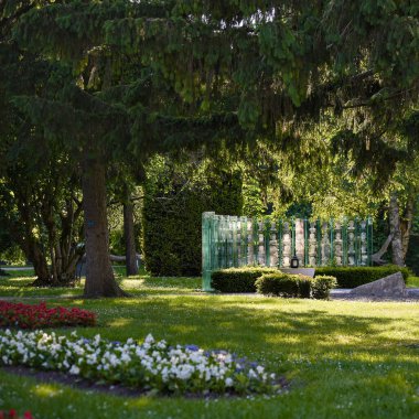 Gölgeli çiçek parkında şeffaf heykel kurulumu