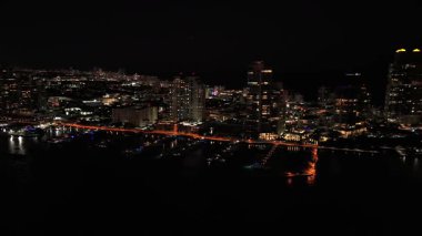 Miami ufuk çizgisinin ve parlayan körfez yansımalarının gece drone görüntüsü
