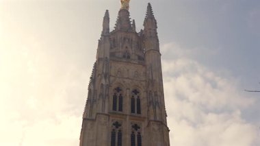Bardeaux Katedrali 'nin alçak açılı çan kulesinin parlak bulutlu gökyüzü altında gotik taş işçiliği