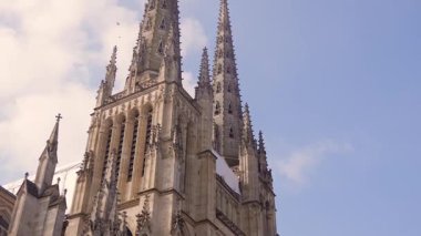 Bordeaux Gotik Katedrali 'nin alçak açılı görüntüsü. Gül pencereli ve mavi gökyüzünün altındaki kuleler.