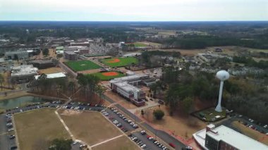 Spor alanları ve binaları olan kampüs su kulesinin insansız hava aracı görüntüsü