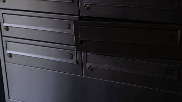 Крупный план металлических почтовых ящиков с одним сломанным замком в современном жилом здании. Реалистичные городские детали, символизирующие безопасность, неприкосновенность частной жизни и ежедневное общение. Идеально подходит для рассказов о городской жизни, жилищных условиях, содержании и безопасности.