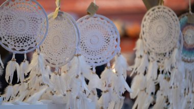 Yayın fotoğrafı Krakow, Polonya 'da, Ekim 2025' te çekildi. Yerel bir markette sergilenen tüylü beyaz el yapımı düş kapanları. Görüntü, tarihi kentteki hakiki zanaatkarlığı, zanaatkarlığı ve sonbahar atmosferini yansıtıyor.