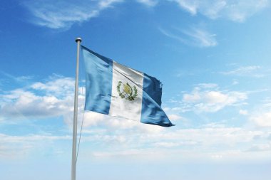 Mavi gökyüzünde dalgalanan Guatemala bayrağı.