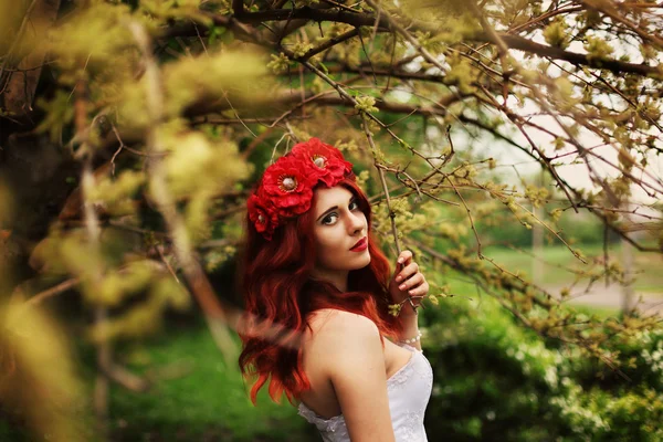Flickan med rött hår på en grön bakgrund — Stockfoto