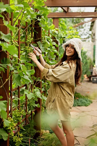 Linda chica con el pelo largo hace grandes tijeras de jardín de corte — Foto de Stock