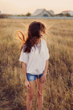 Uzun kahverengi saçlı kalmak çayır ile genç kız. 