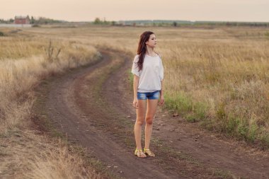 Uzun kahverengi saçlı genç kız alan yolda kalır