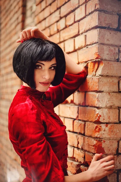 Chica morena joven en vestido rojo romántico vintage cerca de la pared — Foto de Stock
