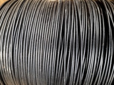 Büyük bir siyah elektrik kablosu bobinini kapatın, endüstriyel doku.