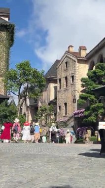 Ziyaretçiler Ba Na Hills Vietnam sokaklarında ellerinde renkli şemsiyelerle geziyor ve ellerinde sırt çantalarıyla geziyorlar. Manzaranın ve turistik manzaranın tadını çıkarıyorlar..