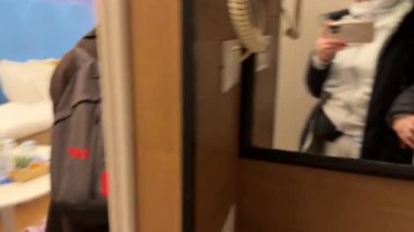 Kadın bir odaya elektronik kilitle giriyor. Anahtarı aramak için odada dolaşıyor. Bir pencere açıyor. Sırt çantalı bir kız gezgindir. Roma, İtalya 11.24.2025