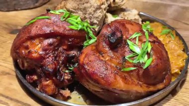 17 saatten uzun bir süre sous vide 'da kaynatılmış yumuşak domuz budu, altın bir kabuğa yapışmış, haşlanmış lahana, fırında ekmek ve yeşil soğanla servis edilmiş. Yüksek kalite 4k görüntü