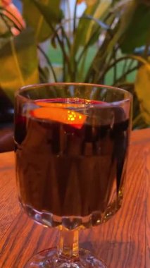 Arkaplanda Bulanık Şömine ile Noel Pazarı 'nda Sıcak Sıcak Şarap Tutan Eller. Yüksek kalite 4k görüntü