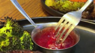 Yakın plan. Bir bıçak yumuşak bir parça kızarmış ördek göğsünü dilimler, armut konservesi ve keskin kızılcık sosuyla servis edilir. Güzel bir restoran için mükemmel bir gurme bayram yemeği.. 