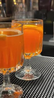 İki bardak Aperol Spritz Venedik, İtalya 'daki Rialto Köprüsü' nün olduğu bir masada oturur. Arka planda gece bulanıklaşır. Mükemmel bir İtalyan akşamı. Yüksek kalite 4k görüntü