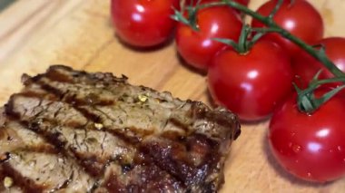 Biftek, otlar, sarımsak ve domateslerle servis panosuna yakın çekim. Üst Manzara. Yüksek kalite 4k görüntü