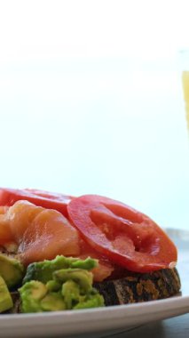 Dilimlenmiş avokado sandviçli lezzetli ve sağlıklı bir kahvaltı. Yanında da kızarmış yumurta. Sağlıklı beslenme konsepti. Avokado kahvaltı suyu