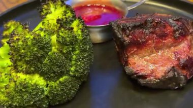 Patates püresi, havuç, brokoli, vişneli domates ve soslu gurme biftek tabağı. Zarif bir yemek takımı. Yemek fotoğrafçılığı, barbekü bifteği ve brokoli için mükemmel..