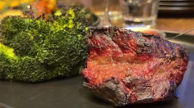 Patates püresi, havuç, brokoli, vişneli domates ve soslu gurme biftek tabağı. Zarif bir yemek takımı. Yemek fotoğrafçılığı, barbekü bifteği ve brokoli için mükemmel..