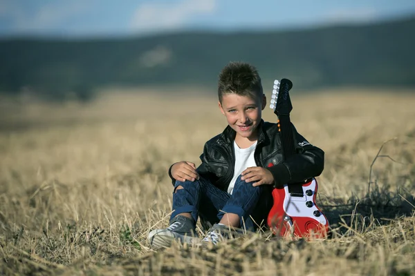 bir çocuk alanında oturmuş oyuncak gitar