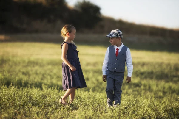 bir erkek ve bir kız birbirine günbatımı ışıkta bakarak