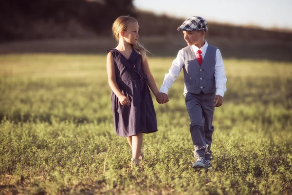 A boy and a girl looking at each other and holding hands Stock Image. 