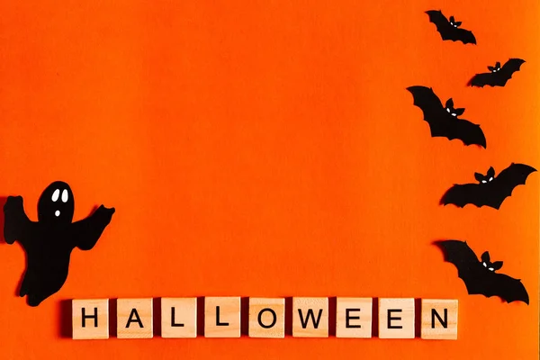 Letras de Halloween sobre fondo naranja con siluetas de papel negro, murciélagos, calabaza, araña. El concepto de Halloween. la vista desde la parte superior —  Fotos de Stock