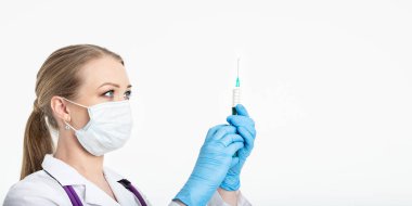 Maskeli genç hemşire aşıyı bir hastanenin yanında otururken şırıngaya çeviriyor. Kadın hasta grip enjeksiyonunu bekliyor. Aşı kavramı ve gribe karşı koruma