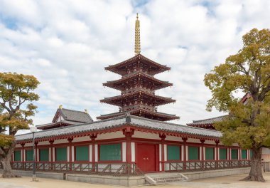 Japon Osaka 'daki Shi-Tennoji Budist Tapınağı' ndaki geleneksel mimari yapı ve pagoda kırmızı ve altın renkli tapınak.