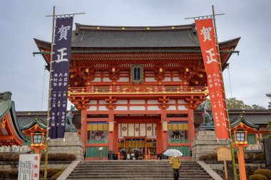 Kyoto Japonya 'daki Fushimi Inari Tapınağı' nın güzel kırmızı kapı girişi. Fotoğraf bulutlu bir günde çekildi.. 