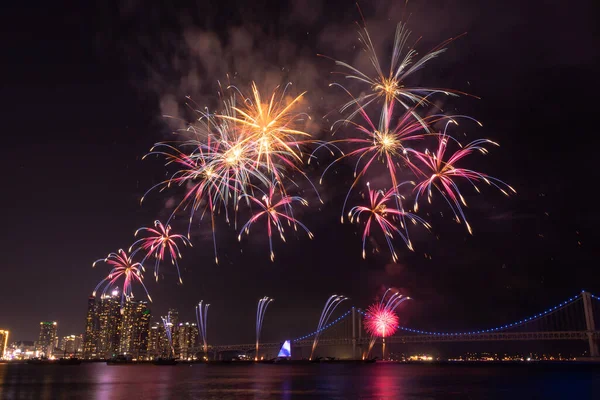 Gece gökyüzünde parlak, renkli havai fişekler. Fotoğraf Busan, Güney Kore 'de çekildi.