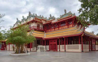 Ayutthaya Tayland 'daki Bang Pa Kraliyet Sarayı' nın bahçesinde bulutlu bir günde renkli kırmızı ve sarı tapınak binası.