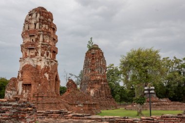 Kırmızı tuğla ve taş tapınak harabeleri bulutlu bir günde Tayland 'da Ayutthaya' da Wat Maha 'nın kompleks yapılarını inşa ediyor.