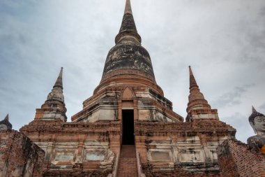 Tayland 'da Ayutthaya' daki Wat Yai Chai Mongkhon tarihi parkının binası ve altın Buda heykeli kırmızı tuğlalar ve taş tapınak harabesi