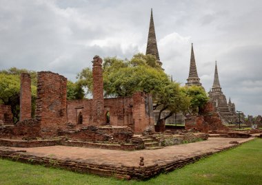 Kızıl tuğla ve taş tapınak, bulutlu bir günde Tayland 'daki Ayutthaya kentindeki Wat Phra Si Santhe tarihi mekanının pagoda kompleks binalarını yıkıyor.