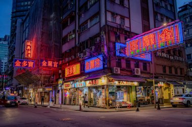 Hong Kong şehir merkezindeki binalar ve iş yerleri boyunca renkli neon reklamlar. Fotoğraf akşamleyin çekildi.