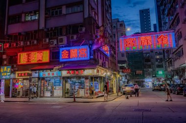 Hong Kong şehir merkezindeki binalar ve iş yerleri boyunca renkli neon reklamlar. Fotoğraf akşamleyin çekildi.